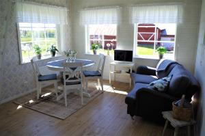 a living room with a blue couch and a table at Ekereds Gårdsstuga in Dalstorp