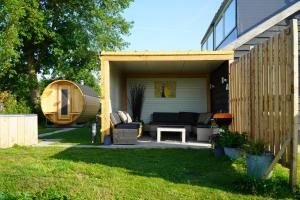 a shed with a couch and a table in a yard at Groepsverblijf "De Klosse" in Wanneperveen