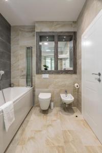 een badkamer met een bad, een toilet en een wastafel bij Elixir luxury rooms in Split