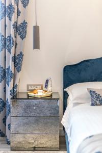 een slaapkamer met een blauw en wit bed en een nachtkastje bij Elixir luxury rooms in Split
