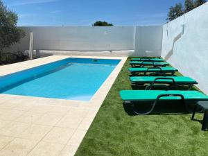 a row of lounge chairs next to a swimming pool at Painel de Monsaraz in Reguengos de Monsaraz