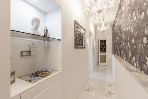 een hal met witte muren en een kroonluchter bij Elixir luxury rooms in Split