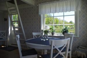 a dining room with a blue table and a window at Ekereds Gårdsstuga in Dalstorp