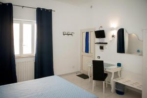 una camera da letto con scrivania, letto e finestra di B&B La Pineta a Orbetello