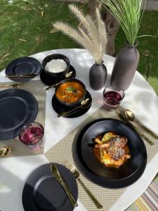una mesa con platos negros de comida. en The Postcard Gir Wildlife Sanctuary, en Sasan Gir