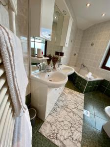 een badkamer met een wastafel, een bad en een wastafel bij Apartma Bernard in Radovljica