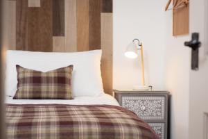 a bedroom with a bed with a pillow and a lamp at Redlands Country Lodge Apartments with Hot Tubs in Ladybank