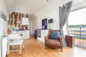 a living room with a chair and a kitchen at Redlands Country Lodge Apartments with Hot Tubs in Ladybank
