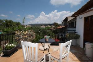 a patio with two chairs and a table and some plants at Giorgos House Attic in Gialova