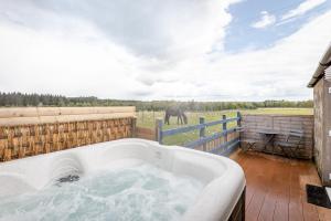 a bath tub on a deck with an elephant in the background at Redlands Country Lodge Apartments with Hot Tubs in Ladybank