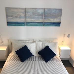 a bedroom with a bed with two blue pillows at Casa Giorgia Monopoli in Monopoli