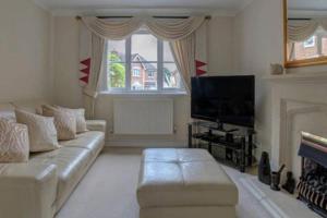 a living room with a couch and a television at Luxury 4 Bedroom House in Manchester