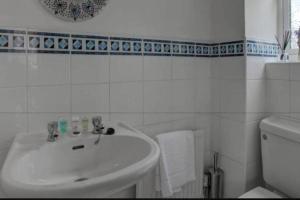 a white bathroom with a sink and a toilet at Luxury 4 Bedroom House in Manchester +14 photos