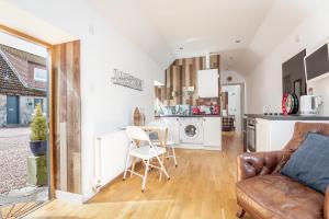 a kitchen and living room with a couch and a table at Redlands Country Lodge Apartments with Hot Tubs in Ladybank