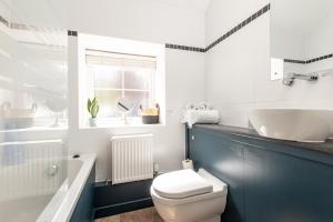 a bathroom with a white toilet and a tub and a sink at Redlands Country Lodge Apartments with Hot Tubs in Ladybank