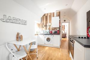a kitchen with a washing machine and a washer and dryer at Redlands Country Lodge Apartments with Hot Tubs in Ladybank