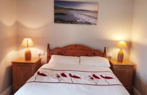 a bedroom with a bed with red roses on it at Bridgeview Farmhouse Bed and Breakfast in Kilbrittain