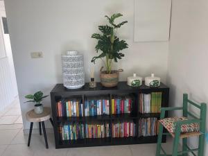 ein Bücherregal mit Büchern neben zwei Stühlen in der Unterkunft Huisje op den Diek in Sint Kruis