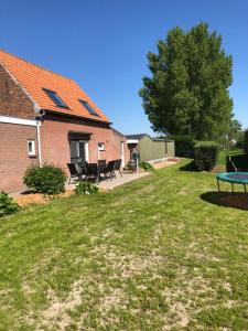 a yard with a picnic table and a house at Huisje op den Diek in Sint Kruis