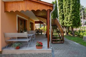 a patio with a staircase and a table and benches at Akácfa 13 Apartman in Zalakaros