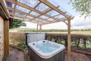 a hot tub under a pergola at Redlands Country Lodge Apartments with Hot Tubs in Ladybank