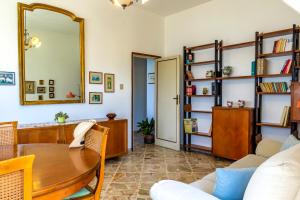 ein Wohnzimmer mit einem Tisch und einem Spiegel in der Unterkunft La Casa di Elvira in Giardini-Naxos
