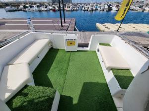 a boat with green grass on a dock with boats at Experiencia en el mar Gijon M in Gijón