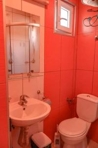 a red bathroom with a toilet and a sink at Apartman Saraiste in Ohrid
