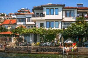a large white house sitting next to a body of water at Apartman Saraiste in Ohrid
