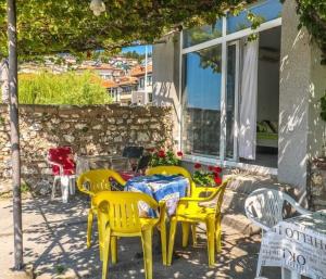 a group of yellow chairs and a table in front of a building at Apartman Saraiste in Ohrid +3 photos