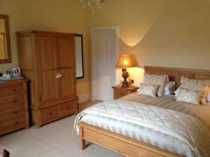 1 dormitorio con 1 cama, vestidor y lámpara en Buccleuch Guest House, en Fort William