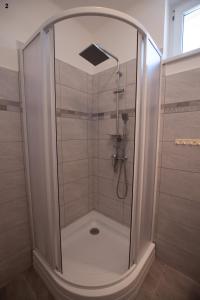 W łazience znajduje się prysznic ze szklanymi drzwiami. w obiekcie Akácfa 13 Apartman w Zalakaros +16 zdjęć