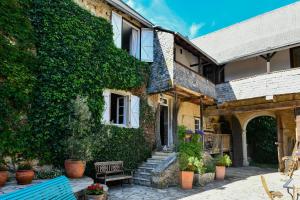 an ivy covered building with a blue bench in front at La Ferme Dagué in Lasseube +26 photos