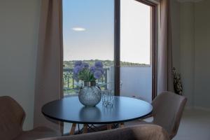 einen blauen Tisch mit einer Vase mit lila Blumen drauf in der Unterkunft Rafaela Apartments in Istro