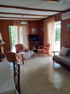 salon z krzesłami, kanapą i telewizorem w obiekcie Villa Sunrise Seaside w Kalamácie