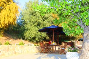 uma mesa com um guarda-sol e cadeiras debaixo de uma árvore em Cuore Della Valle em Cefalù