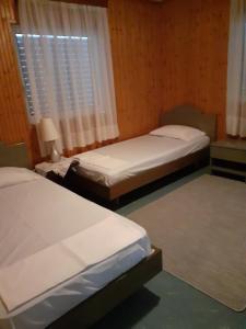 2 łóżka pojedyncze w pokoju z oknem w obiekcie Villa Sunrise Seaside w Kalamácie