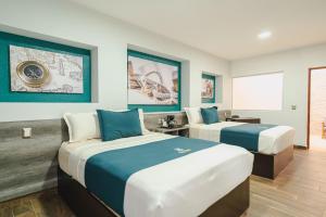 two beds in a room with blue and white at Real Naviero Hotel Ejecutivo in Manzanillo