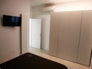 a room with white cabinets and a tv on the wall at Orchidea Beach in Civitanova Marche