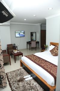 a hotel room with a bed and a tv at Adden Palace Hotel & Conference Centre in Mwanza
