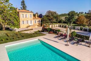 a swimming pool in front of a house at Le Domaine d Eden Château Garreau in Cadillac