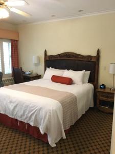a bedroom with a large bed with a red blanket at The Eagle Inn in Santa Barbara