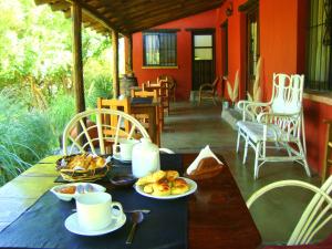 una mesa con tazas y platos de comida. en Cabañas en Piedras Maia en Merlo
