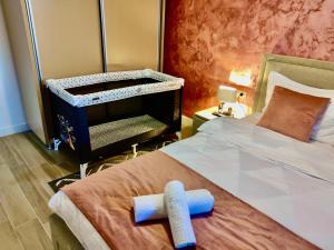 ein Schlafzimmer mit einem Bett und einem Babybett in der Unterkunft Primera Residence Mamaia Nord in Mamaia Nord – Năvodari + 7 Fotos