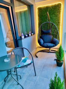 eine Terrasse mit 2 Stühlen, einem Tisch und einer Bank in der Unterkunft Primera Residence Mamaia Nord in Mamaia Nord – Năvodari