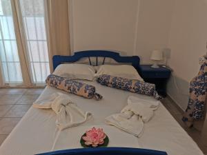 a bed with two towels and a flower on it at Aiantas in Ermoupoli