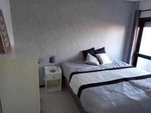 een slaapkamer met een bed en een tafel met een lamp bij Mira House in Praia de Mira