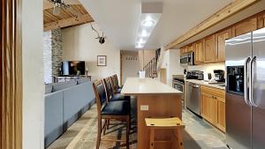 a kitchen with a counter with chairs and a refrigerator at Timberline Condominiums 1 Bedroom plus Loft Deluxe Unit A3C in Snowmass Village