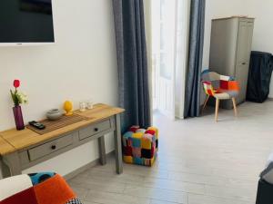 ein Wohnzimmer mit einem Tisch und einem Stuhl in der Unterkunft Ortyx Mini Suite in Syrakus