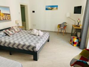 Schlafzimmer mit einem Bett, einem Schreibtisch und einem Stuhl in der Unterkunft Ortyx Mini Suite in Syrakus